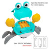 A blue interactive crab toy with yellow claws and an open shell, showing the battery compartment.
