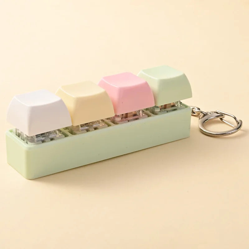A colorful acrylic fidget keychain featuring four clicky key buttons in pastel shades.