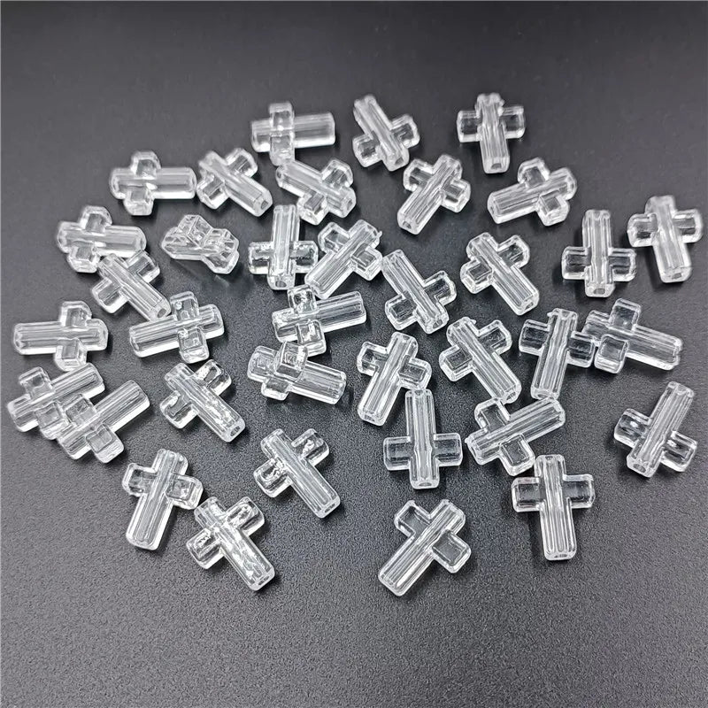 A pile of clear acrylic cross beads for jewelry making
