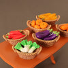 A miniature dollhouse vegetable basket play set filled with various colorful vegetables like carrots, peppers, and greens.