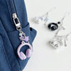 A collection of beaded wing cross phone lanyards and keychains hanging from a dark blue fabric.