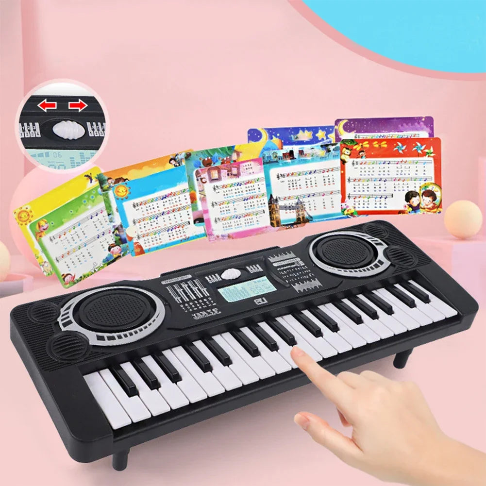 A black 37-key kids electronic keyboard with a microphone and colorful sheet music displayed on a pink background.