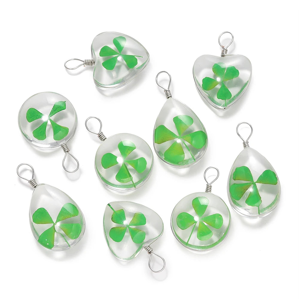 A set of handmade glass four leaf clover pendants with silver jump rings.