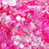 A close-up of mixed pink and clear acrylic loose beads for jewelry making