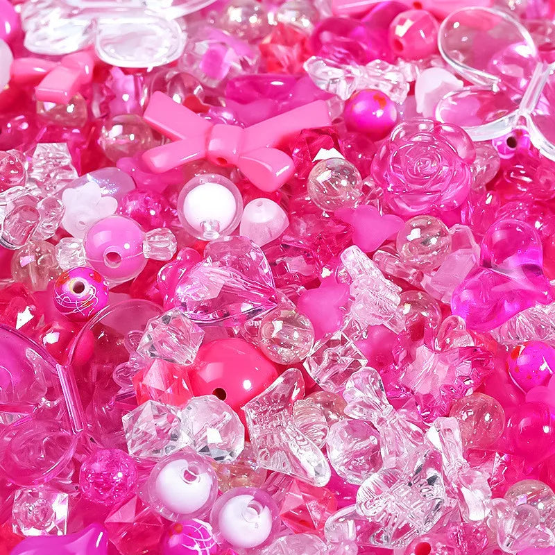 A close-up of mixed pink and clear acrylic loose beads for jewelry making