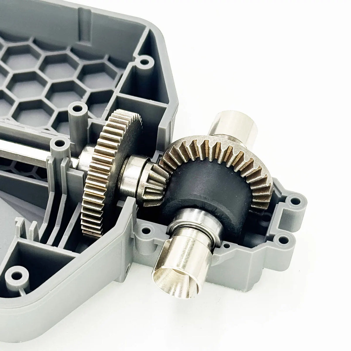 A close-up view of a metal gear differential upgrade kit for RC cars, showing the gears and mounting components.