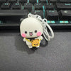 A white cartoon bear couple keychain set with pink accents and a yellow bear charm resting on a black keyboard.