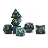 A set of seven polyhedral dice in dark teal or emerald green glass with gold accents, including a d3, d6, d8, d10, and d20.