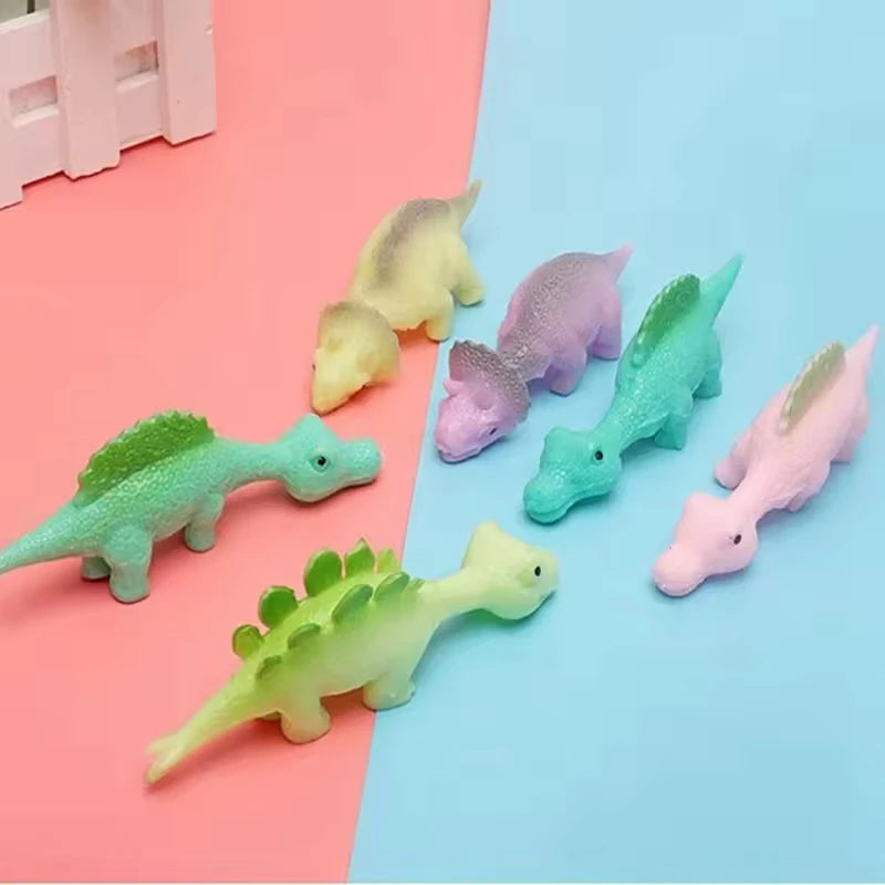 A set of sticky rubber dinosaur slingshot toys in various pastel colors like yellow, purple, and green.