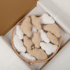 A collection of handmade felt baby mobiles featuring various white and beige clouds and moon shapes in a wooden bowl.