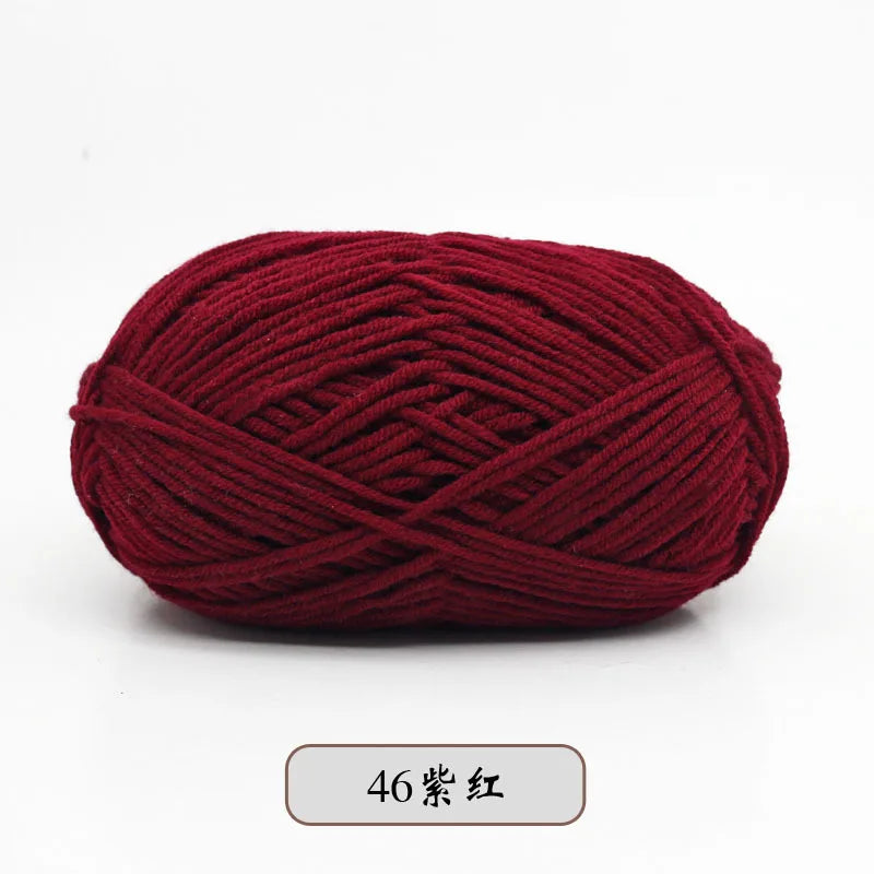 A ball of deep maroon pre-dyed milk cotton yarn used for knitting and crochet projects.