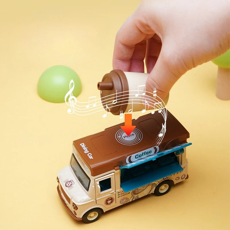 A hand is placing a small coffee cup into the open door of a brown 1:36 scale dining car toy truck.