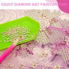 A diamond painting kit showing various colored seed beads and a pink drill pen on a green tray.