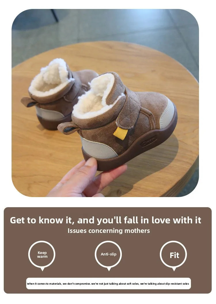 A pair of brown plush-lined winter boots for toddlers resting on a wooden surface.