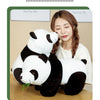 A woman is holding a white and black bamboo panda plush stuffed animal doll.