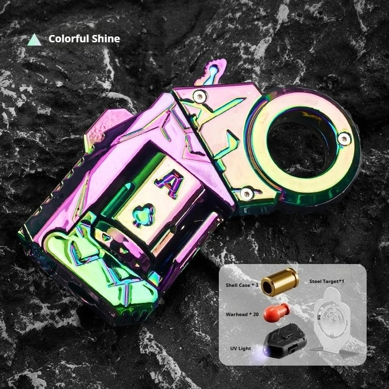 A colorful, metal gun-shaped fidget slider with a circular opening is displayed on a dark, textured surface.