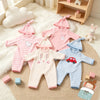 A collection of adorable pink and blue cotton outfits for 12-inch dolls, including hats and full body clothing.