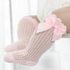 Pink lace knee socks for a baby girl with a decorative bow