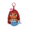A vinyl figure of a character with reddish-brown hair, pink skin, and blue scales, attached to a red hook.
