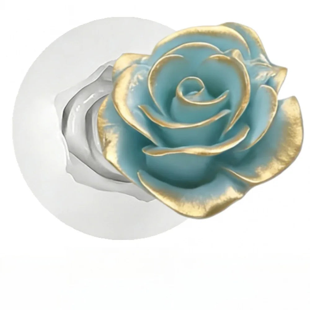 A silicone mold shaped like a blue-green rose with gold accents for decorating cakes and fondant.