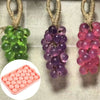 Three clusters of silicone grape molds in green, purple, and pink hanging from twine.