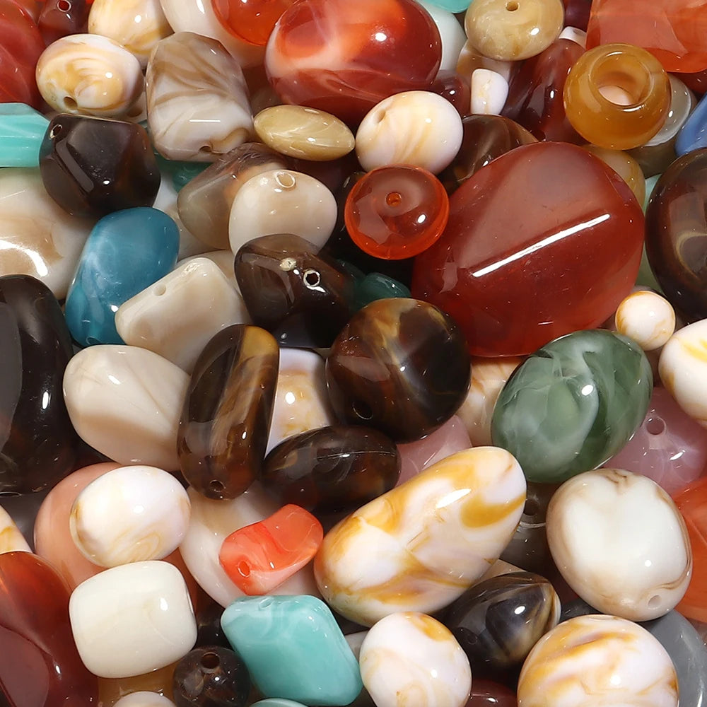 A close-up view of a mixed assortment of colorful, polished acrylic beads for jewelry making and crafts.