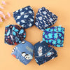 Colección de pantalones de entrenamiento lavables a juego de azul y blanco para bebés, dispuestos en círculo.