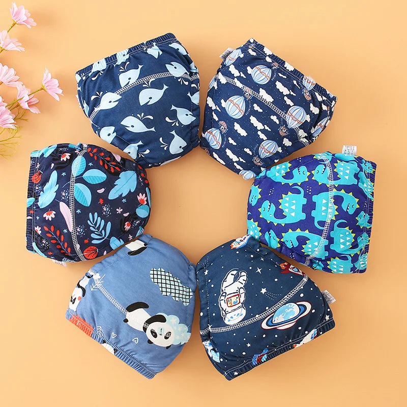 Colección de pantalones de entrenamiento lavables a juego de azul y blanco para bebés, dispuestos en círculo.