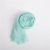 Light mint green knit wrap with a pearl headband, rolled and draped on a white background.