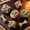 A set of bone and skull carved polyhedral dice resting on a dark leather surface.