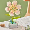 A colorful building block bouquet set featuring pink and yellow rose flowers on a green stem.
