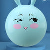 A light blue inflatable hopper ball with bunny ears is shown on a blue stand.