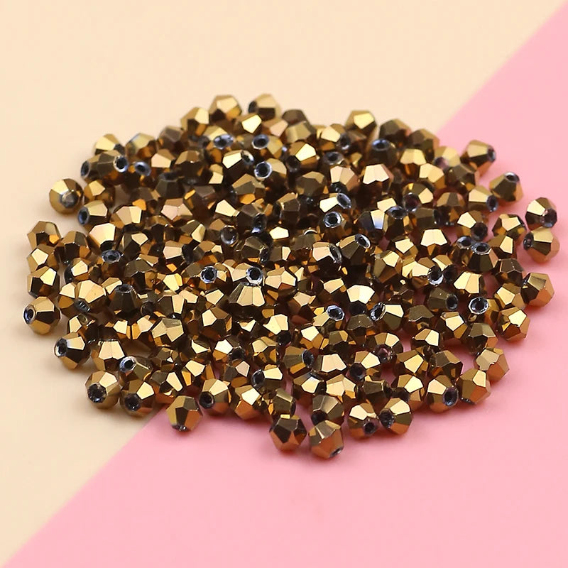 A pile of small, gold-toned electroplated crystal glass beads for jewelry making.