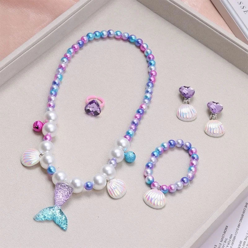 A set of five mermaid pearl jewelry pieces including a necklace and earrings displayed on a light background.