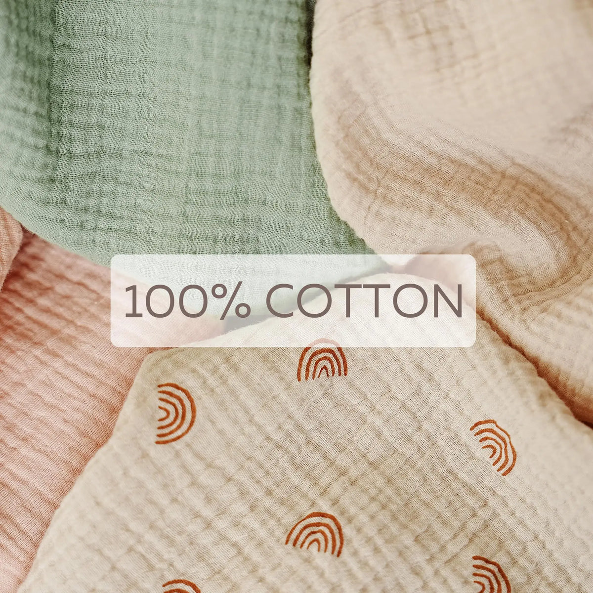 Close-up of soft, textured cotton fabric in sage green and blush pink tones.