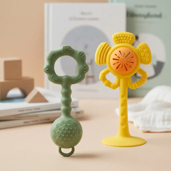 A silicone baby rattle and teether set featuring a green handle and a yellow flower-shaped top.