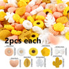 A collection of silicone flower and leaf beads in various colors including yellow, white, peach, and orange.