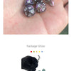 A set of seven iridescent acrylic polyhedral dice in a black velvet bag