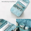 A light blue multifunction toiletry bag with an open compartment showing various toiletries and accessories.