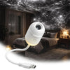 A white projector night light with an adjustable neck and cord is shown illuminating a bedroom scene under a starry sky backd