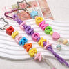 A set of colorful acrylic letter beads in various shades and sizes strung on elastic cord for DIY jewelry making