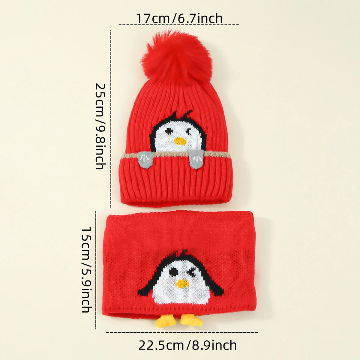 A red knit penguin hat with a fluffy pompom and a matching red knitted scarf.