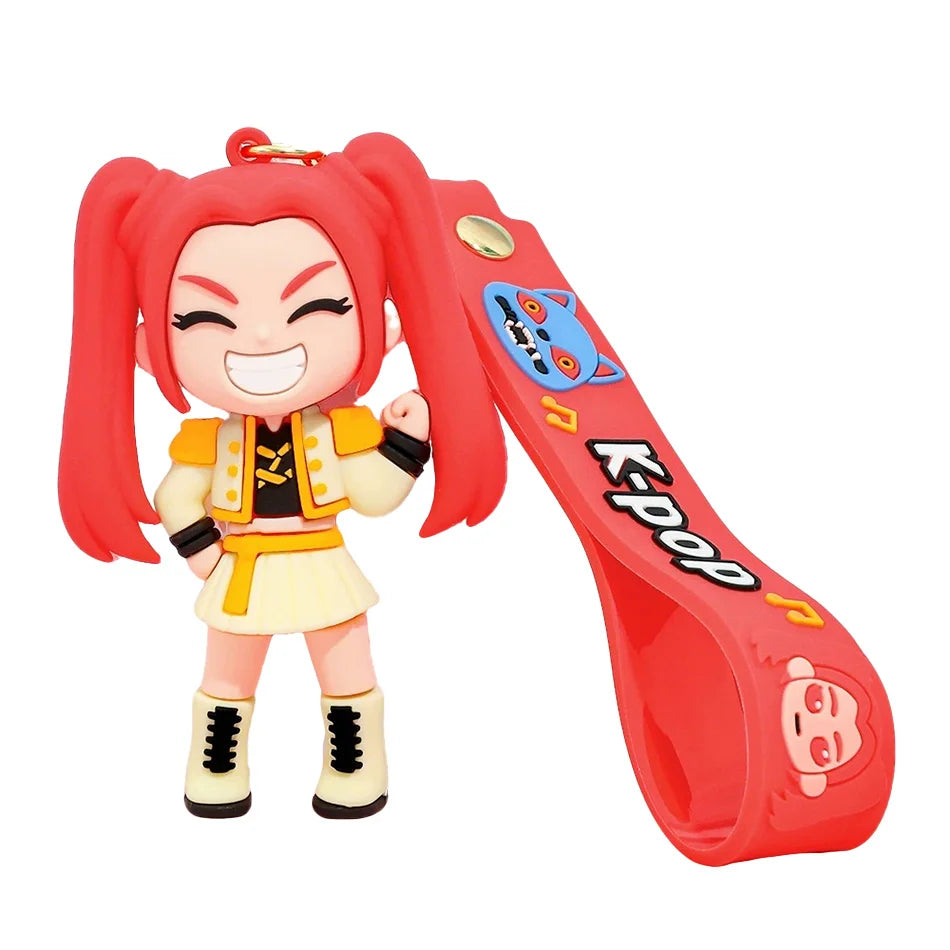 A collectible doll featuring bright red hair and an orange outfit, attached to a red keychain.