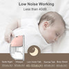 A pink hands-free wearable breast pump device is shown next to a baby sleeping on a white surface.