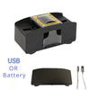 A black automatic card shuffler device with a clear top, shown next to its battery or USB power source.