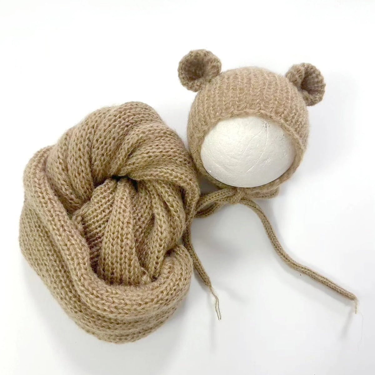 A knitted bear hat and wrap set in a light beige color for newborn photography.