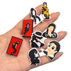 A hand holds a set of 20 Michael Jackson inspired shoe charms and DIY sneaker decorations featuring black and gold designs.