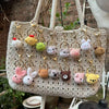 A beige crochet tote bag filled with various animal keychain charms including rabbits, chicks, cats, and dogs.