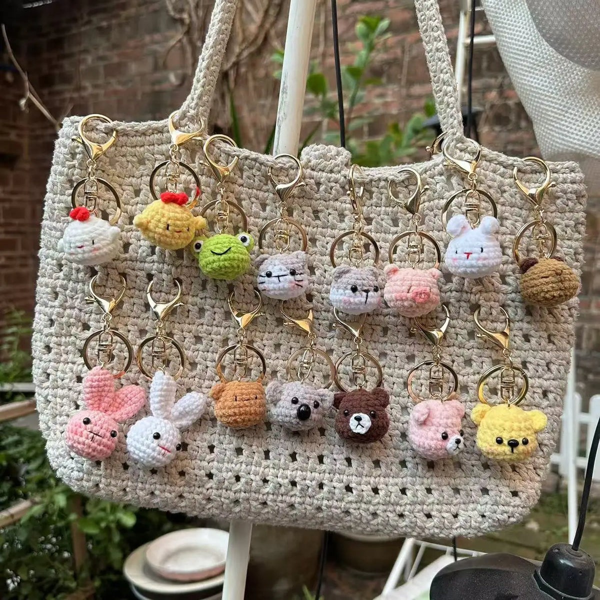 A beige crochet tote bag filled with various animal keychain charms including rabbits, chicks, cats, and dogs.