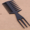 A black plastic comb with widely spaced teeth lying on a light brown surface.